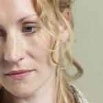 A woman looking thoughtful and a little bit sad.