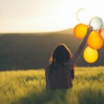 unknown person holding balloons outdoors